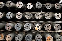Axles for railroad train wheels stored at machine shop awaiting assembly, Tacoma, Washington USA.