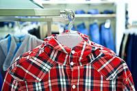 Close-up of blouse, shirt on hanger. Rack, colorful clothing. Fashion in retail store, shop.