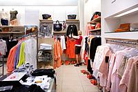 Woman, buyer in fashion shop aisle. Retail outlet and fashion shop interior. Shopping.