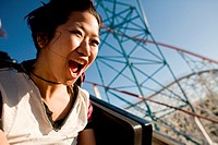 A young woman screams as she rides down a roller coaster in Southern California theme park.
