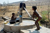 Children pumping water, Orissa, India.