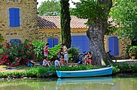 cyclists resting beside the Canal du Midi at Le Somail, Aude Department, France.