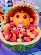 Colorful baby shower fruit sculpture made of various melons.