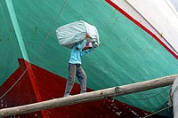 Man carrying goods on his back to load a cargo ship, Sunda Kelapa, Jakarta, Indonesia, Southeast Asia.