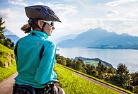 A woman taking a break while moutain biking in the area of Seebodenalp - Weggis on Mount Rigi in Switzerland.