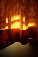 sunlight on orange curtains in room