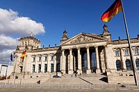 The Reichstag German Parlament building with German and EU flags streaming in the wind outside in Berlin, Germany.