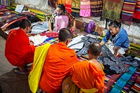 Monks buying fabric at the night market in Luang Prabang, Laos.