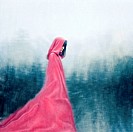 Woman wearing red cloak walking outdoors.