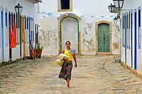 Local brazilian woman walking through the historic center; Paraty, Espirito Santo, Brazil. The beautiful colonial town of Paraty has been a UNESCO Wor...