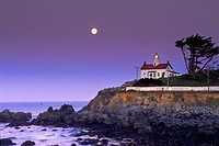 Full moon setting at dawn over Battery Point Lighthouse, Crescent City, Del Norte County, California.