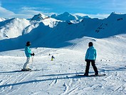 two girls with snowboards and ski´s at skipiste in Flaine, France