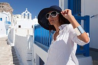 Woman posing in Chora near a church, Amorgos, Cyclades Islands, Greek Islands, Greece, Europe.