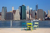 Table and chairs in front of the Downtown Manhattan Skyline from the Brooklyn Bridge Park, Brooklyn, NY, USA.