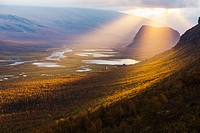 Sarek national park with with the Laitaure delta and mount Namatj in autumn season and the sun breaking through the clouds in Swedish lapland, Sweden.