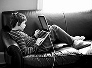 A young boy uses a computer at home.