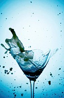 Powerful Splash breaking a martini glass , a conceptual image about alcohol addiction.
