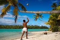 Aitutaki. Cook Island. Polynesia. South Pacific Ocean. An inhabitant of the island takes up a coconut palm tree on the beach in One Foot Island. One F...