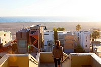 One woman leaves Palisades Park on sunny afternoon, with modern architecture beachfront homes and Pacific Ocean in distance, Santa Monica, City of Los...