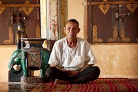 Old man meditating in a pagoda in Siem Reap Cambodia.