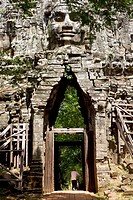 Old man passing through Angkor Thom west gate with his bicycle in Angkor Cambodia.
