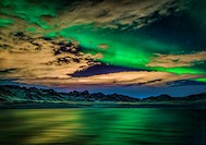 Aurora Borealis over Lake Kleifarvatn, Iceland. Cloudy evening with northern lights reflecting on the lake.