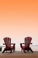 Two chairs on a deck overlooking the ocean, Halifax, Canada, under a saffron sky