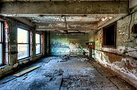 An abandoned office in an old building showing peeling paint on walls and ceiling. Birmingham, Alabama, USA