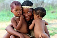 Smiling San mother with her kids, Namibia, Africa.