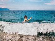 A young girl playing in the waves on a beach in Taiwan during the summer.