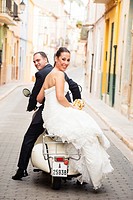 Bridal couple on their journey with a Vespa