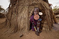 Mursi woman with lip plate in the Lower Omo Valley of Ethiopia. The Mursi girls have a fold cut in their lower lip as they enter womanhood, where a pu...