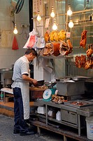 Hong Kong, China, Asia. Hong Kong Kowloon. Roadside butcher with large knife at work.