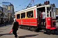 The old tram in the confluence of Istiklal Cadessi and Taksim Square and Turkcell cellular phone operator publicity placard . Istanbul. Turkey.