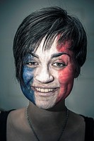 Portrait of happy woman with flag of France painted on face.