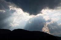 Sun rays stream from a cloud above the Adirondack Mountains near Ticonderoga in upstate NY, USA, North America