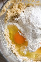 Flour, egg and other baking ingredients in a mixing bowl.