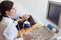 Doctor performs ultrasound on the thyroid gland.