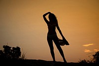 Female silhouette of a girl backlit, sunset on the beach