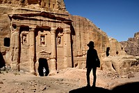 Silhouette of a woman watching the façade of the Roman Soldier´s Tomb, carved out of a sandstone rock face. Jordan (Hashemite Kingdom of), Ma´an Gover...