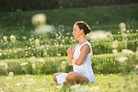 Middle aged woman doing yoga in a park in summer, Germany.