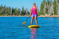 A woman riding the Standup Paddle Board at Lake Cleveland on Mount Harrison high on in the Albion Mountains in southern Idaho.