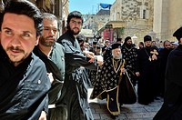 Christian Orthodox monks holding hands protect priests from flow of people during Good Friday procession in Old Town of Jerusalem, Israel.