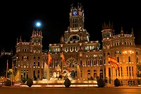 The full Moon rises over the Palacio de Cibeles (1919) built by Antonio Palacios to house the headquarters of the postal service until 2007 when it be...