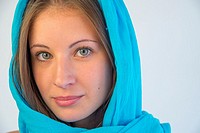 Portrait of blonde young woman wearing turquoise shawl.