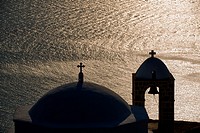 sunset, reflection and chapel at plaka on Milos island in greece