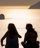 girlfriends enjoy seaview from milos greece at sunset