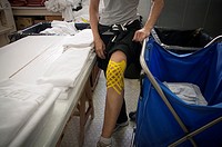 A runner in the physiotherapy room shows her knee after participating in a marathon. Madrid. Spain.