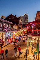 Crowds of visitors walk along Bourbon Street in the Fench Quarter twilight enjoying the nightlife of New Orleans, Lousiana