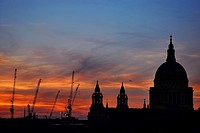 St. Paul´s Cathedral in London, England, and cranes from the many building sites near it, seen against a spectacular sunset.
